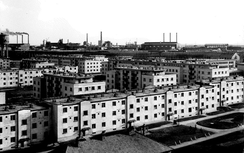 Sztálinváros legkorábban megépült házai, a háttérben a vasművel. Fotó: Sztálinváros-fotóalbum, MÉM MDK Múzeumi Osztály, Adattári gyűjtemény